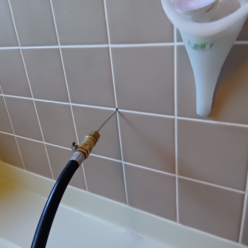 浴室壁の目地からシロアリ駆除剤を注入