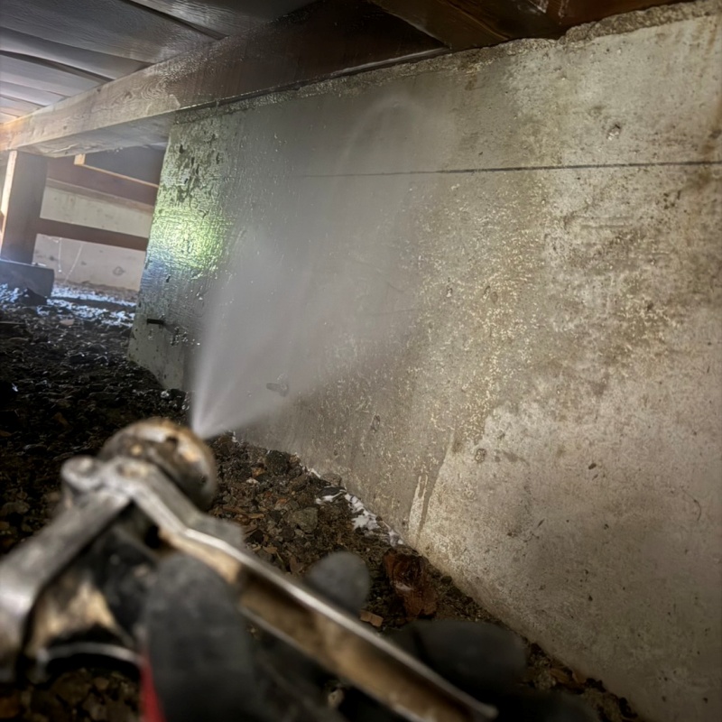 基礎にシロアリ駆除剤を吹き付ける様子