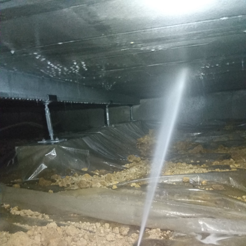 床下断熱材に防蟻剤を吹き付けている様子