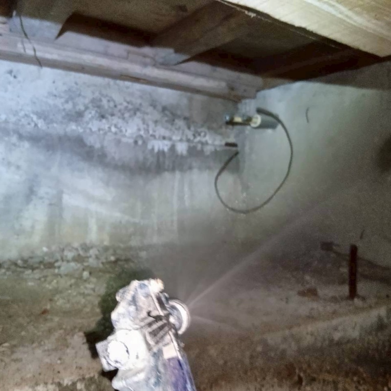 床下木材・断熱材にシロアリ駆除剤を吹き付ける様子