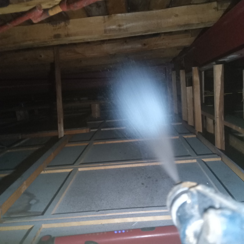 屋根裏の木材にシロアリ駆除剤を散布