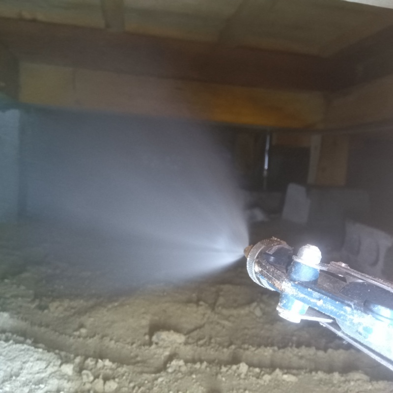 床下木材に防蟻剤を吹き付ける様子