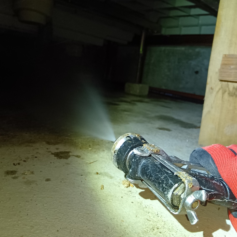 地面にシロアリ駆除剤を吹き付ける様子