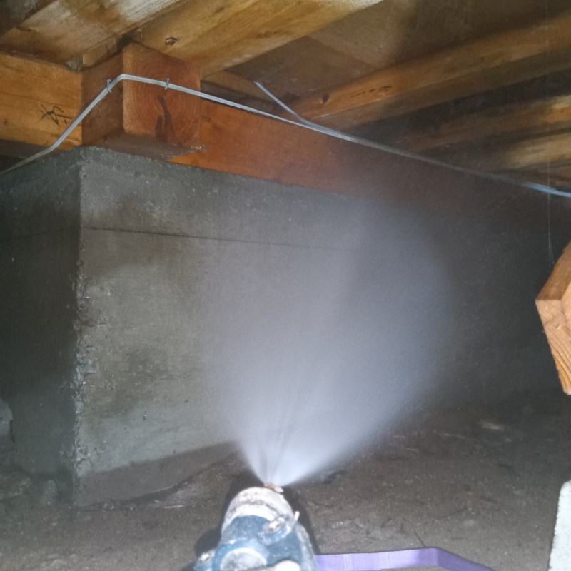 基礎にシロアリ駆除剤を吹き付ける様子