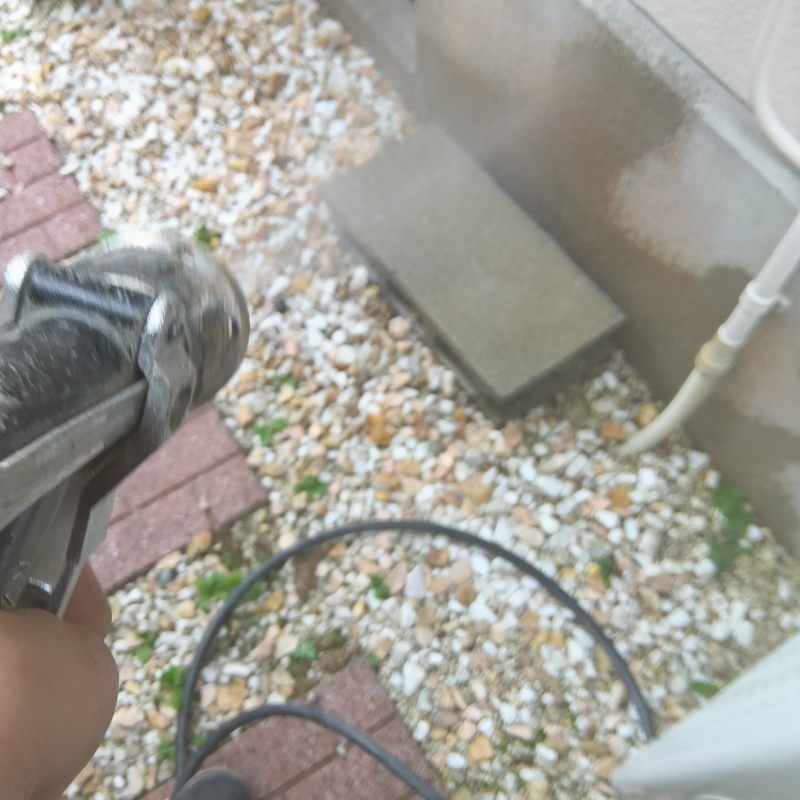 建物外周の土壌にシロアリ駆除剤を吹き付けている様子