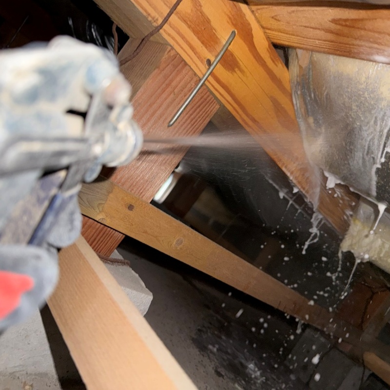 床下断熱材に防蟻剤を吹き付ける様子