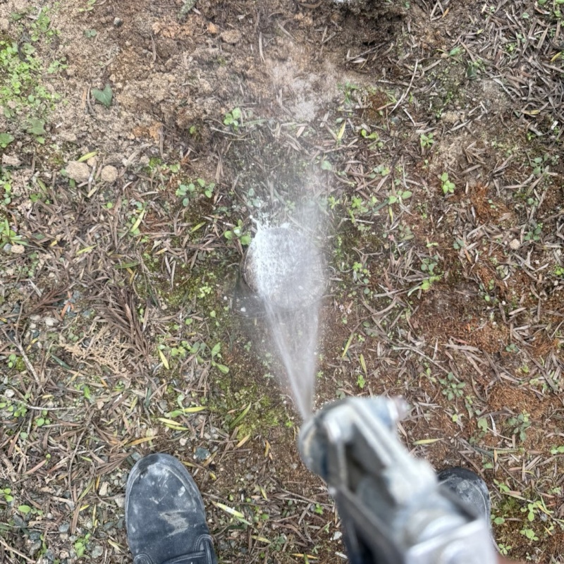 建物外周の土壌に防蟻剤を吹き付ける様子