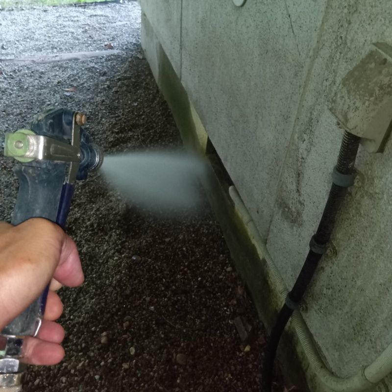 基礎まわりにシロアリ駆除剤を散布する様子