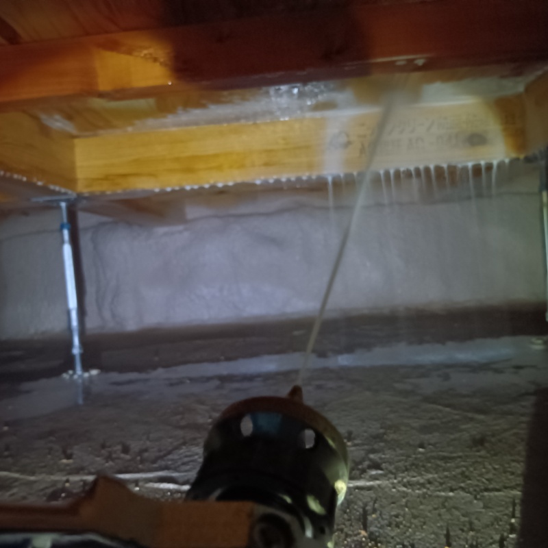 床下木材に防蟻剤を吹き付けている様子