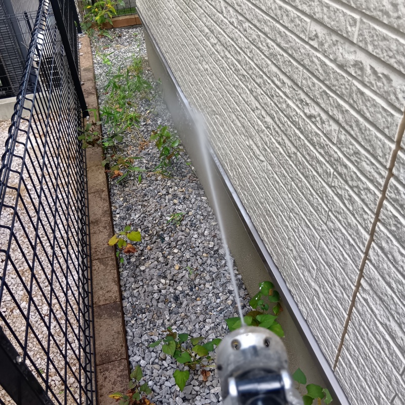 建物外周の土壌に防蟻剤を吹き付けている様子