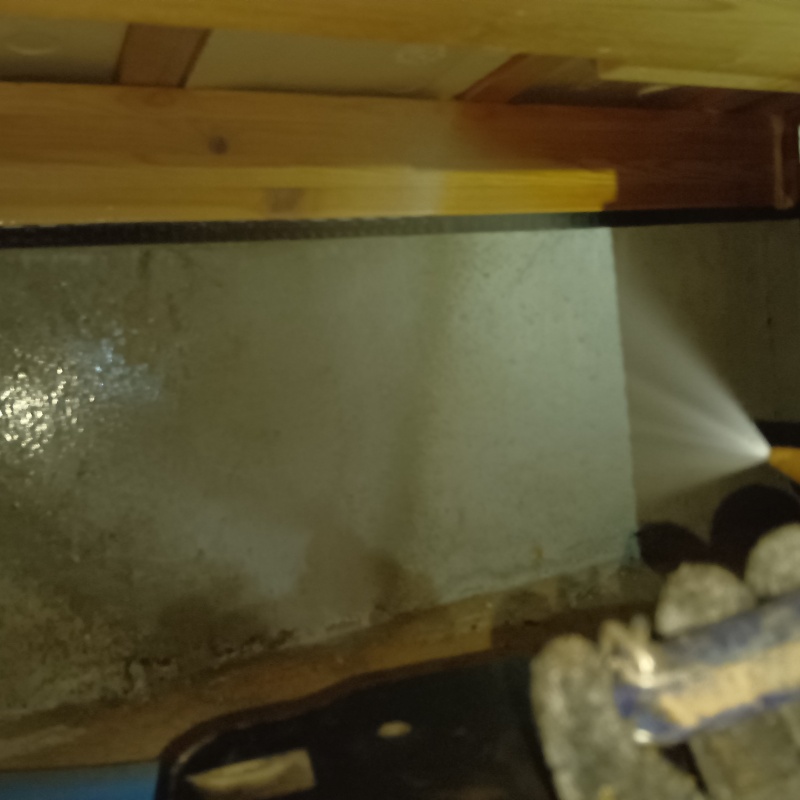 基礎にシロアリ駆除剤を吹き付ける様子