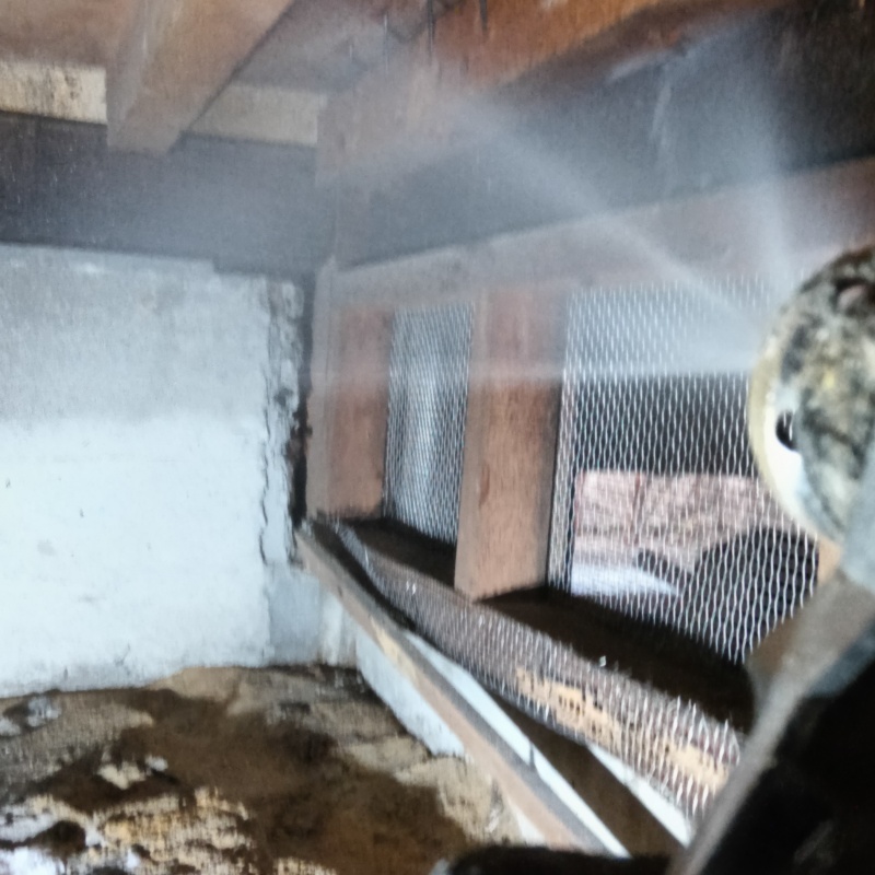 床下木材にシロアリ駆除剤を吹き付ける様子