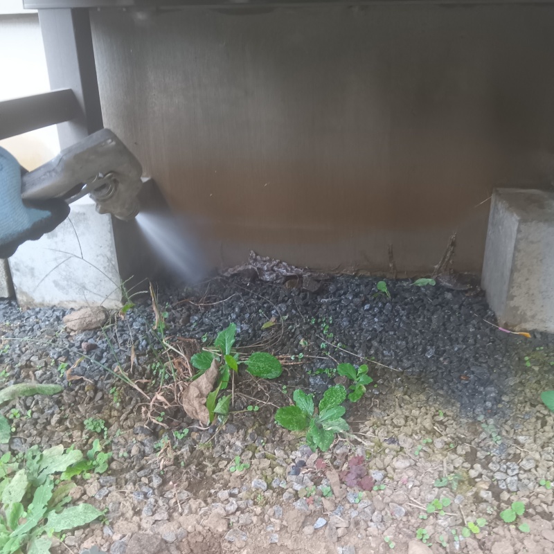 屋外の地面にシロアリ駆除剤を散布