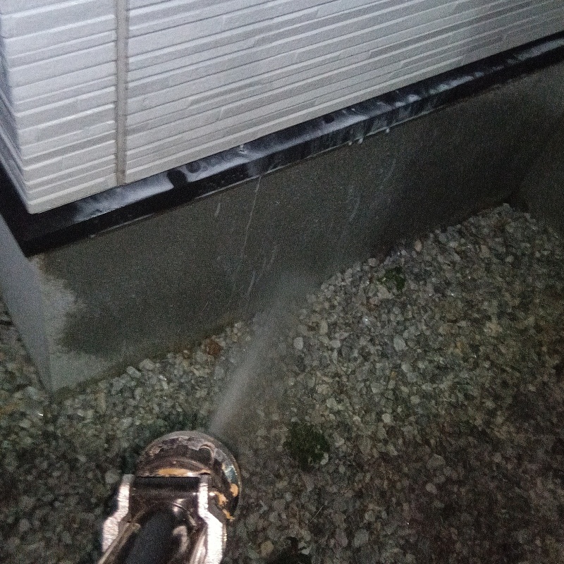 屋外の地面にシロアリ駆除剤を散布