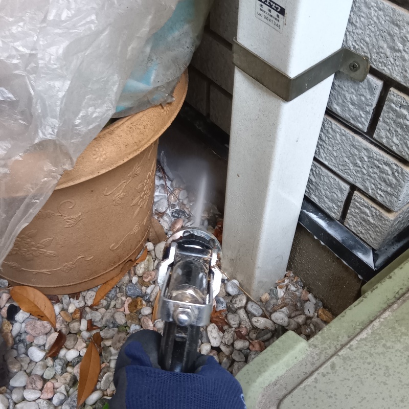 屋外の地面にシロアリ駆除剤を散布