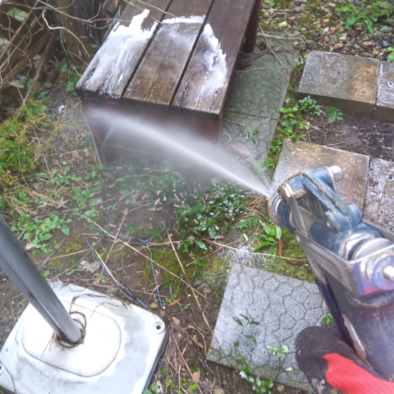 木製ベンチのまわりにシロアリ駆除剤を散布