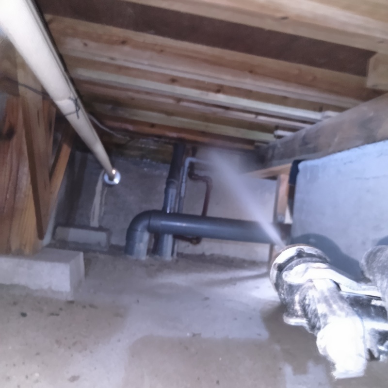 床下木材に防蟻剤を吹き付けている様子