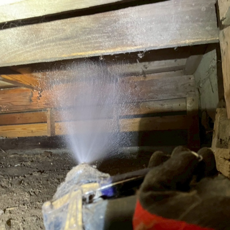 床下木材にシロアリ駆除剤をを散布する様子