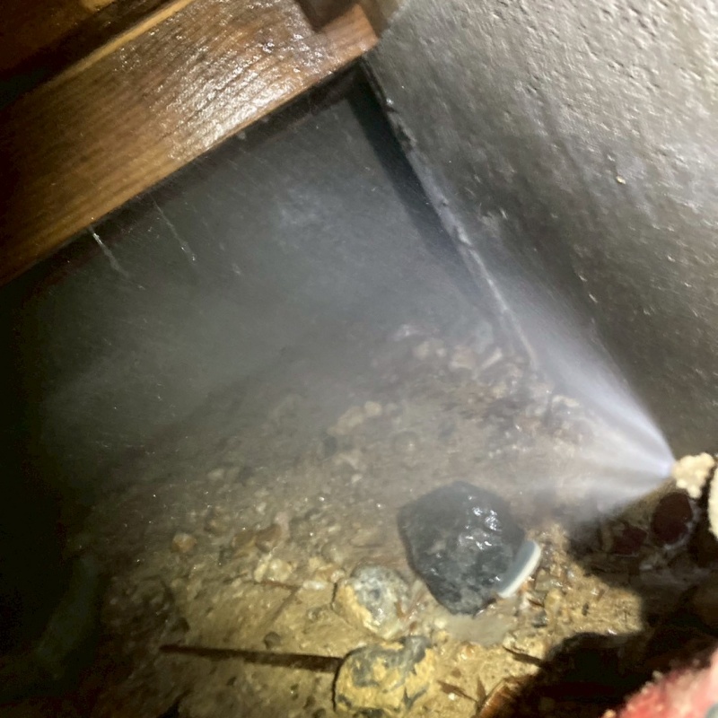 地面にシロアリ駆除剤を吹き付けている様子