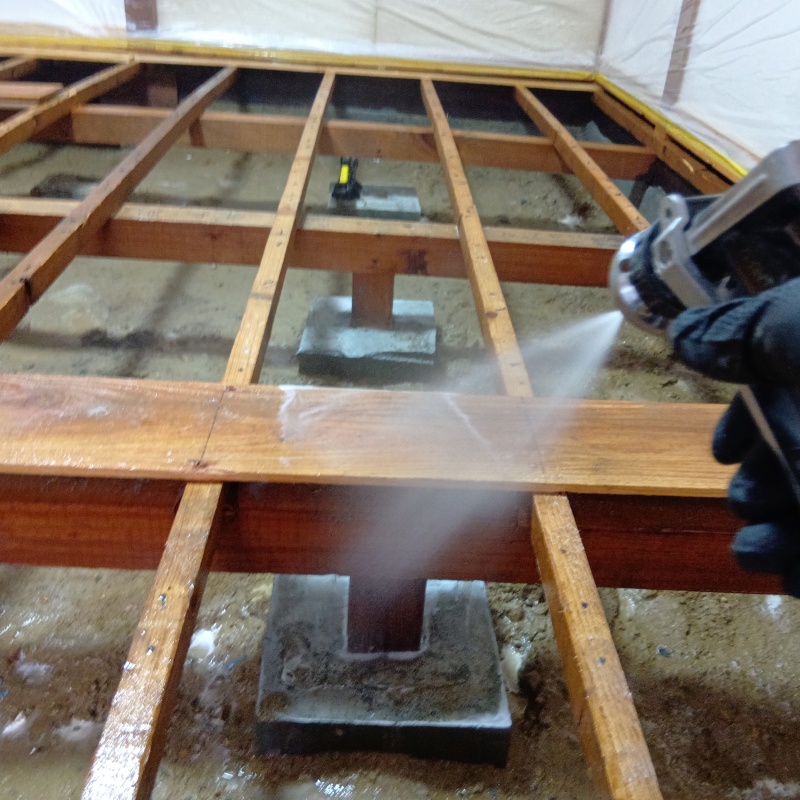 床下木材にシロアリ駆除剤を散布している様子