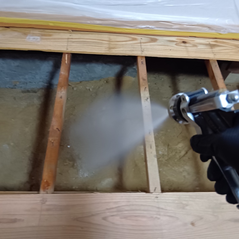 地面にシロアリ駆除剤を散布している様子