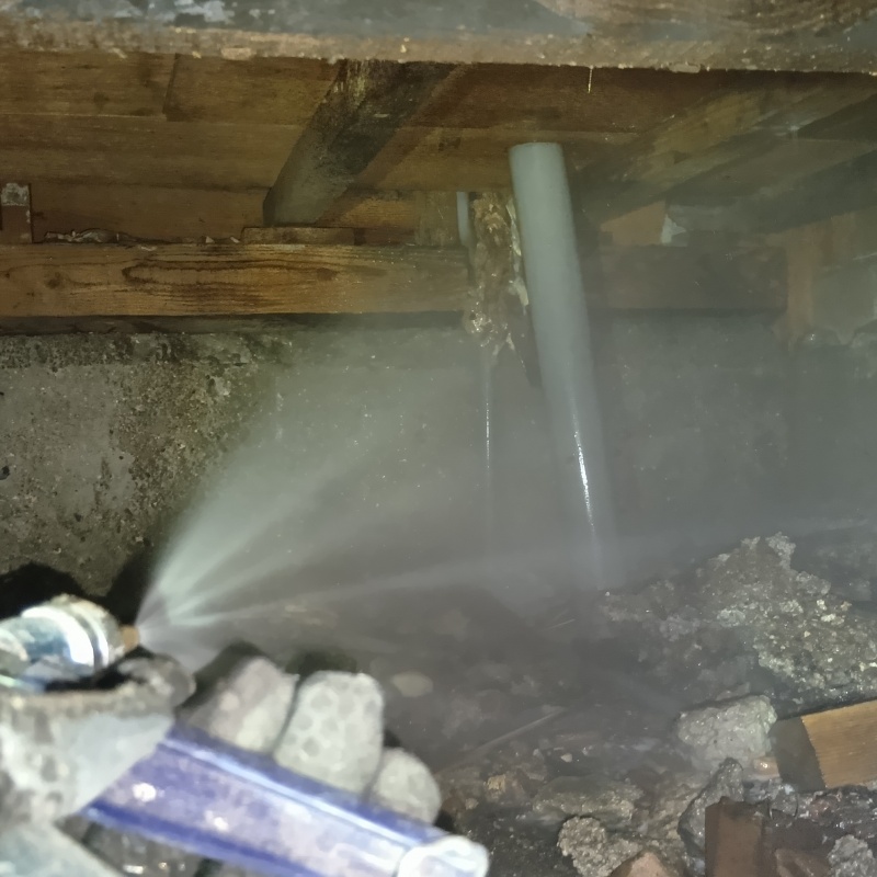 地面にシロアリ駆除剤を吹き付ける様子