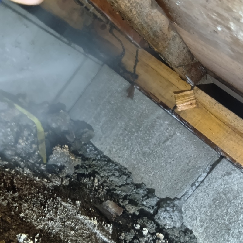 床下木材にシロアリ駆除剤を吹き付けている様子