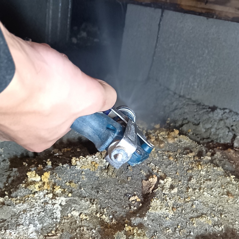 地面にシロアリ駆除剤を吹き付けている様子