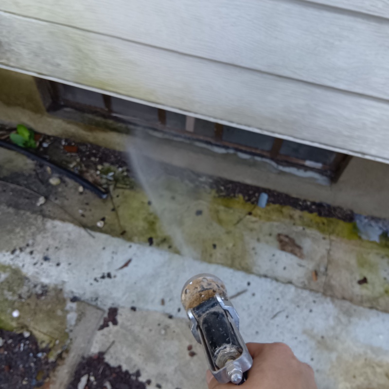 基礎まわりにシロアリ駆除剤を散布する様子