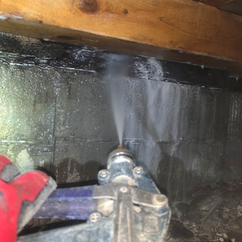 基礎にシロアリ駆除剤を吹き付ける様子