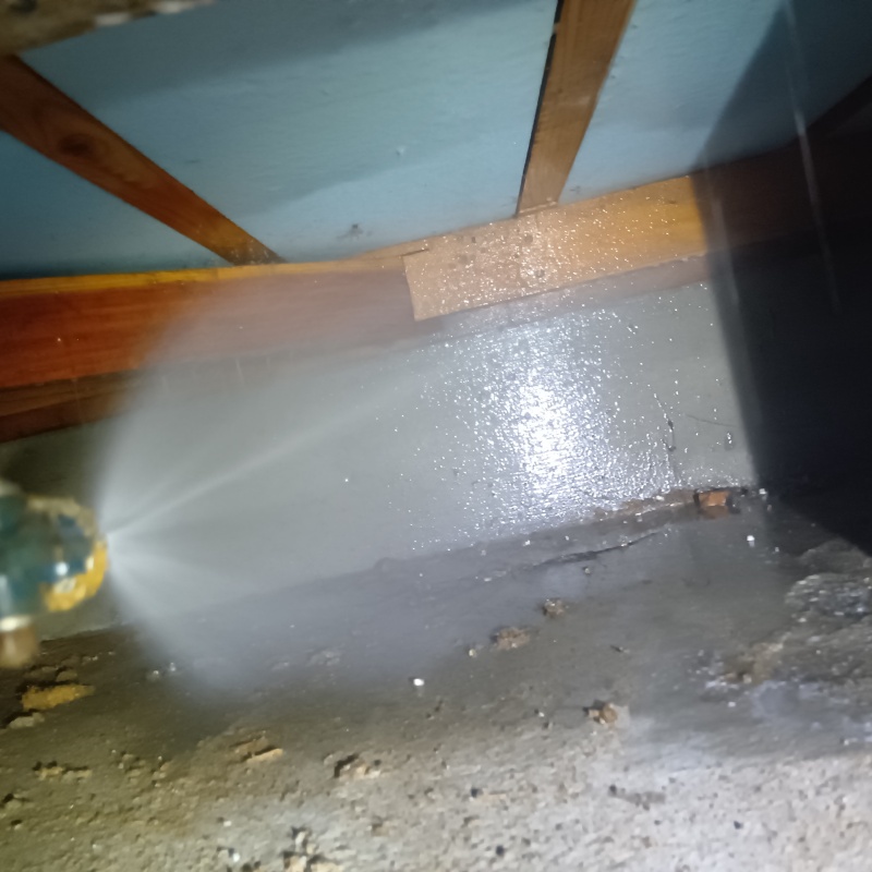 地面にシロアリ駆除剤を吹き付ける様子