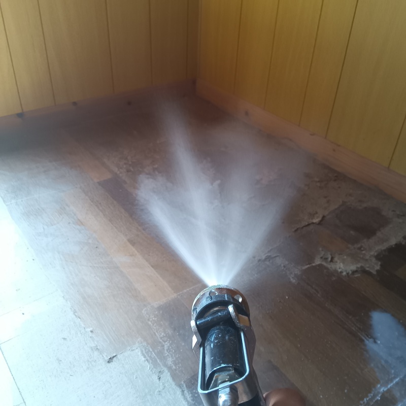 フローリングにシロアリ駆除剤を散布している様子