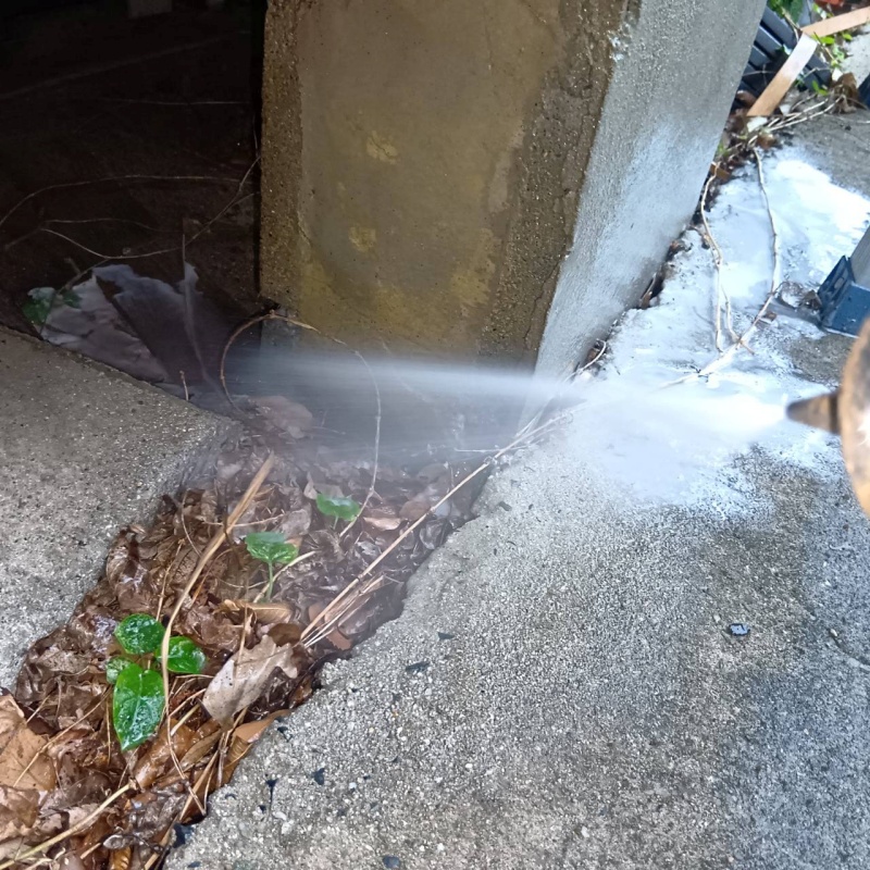 建物外周の土壌にシロアリ駆除剤を散布している様子