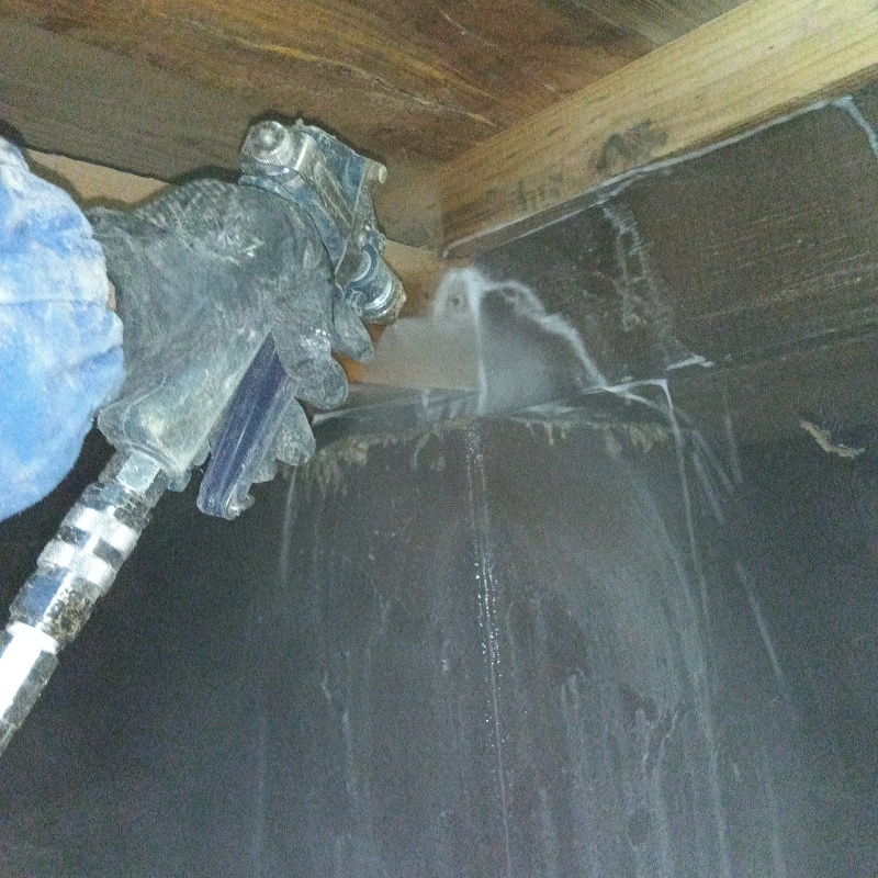 床下木材にシロアリ駆除剤を吹き付ける様子