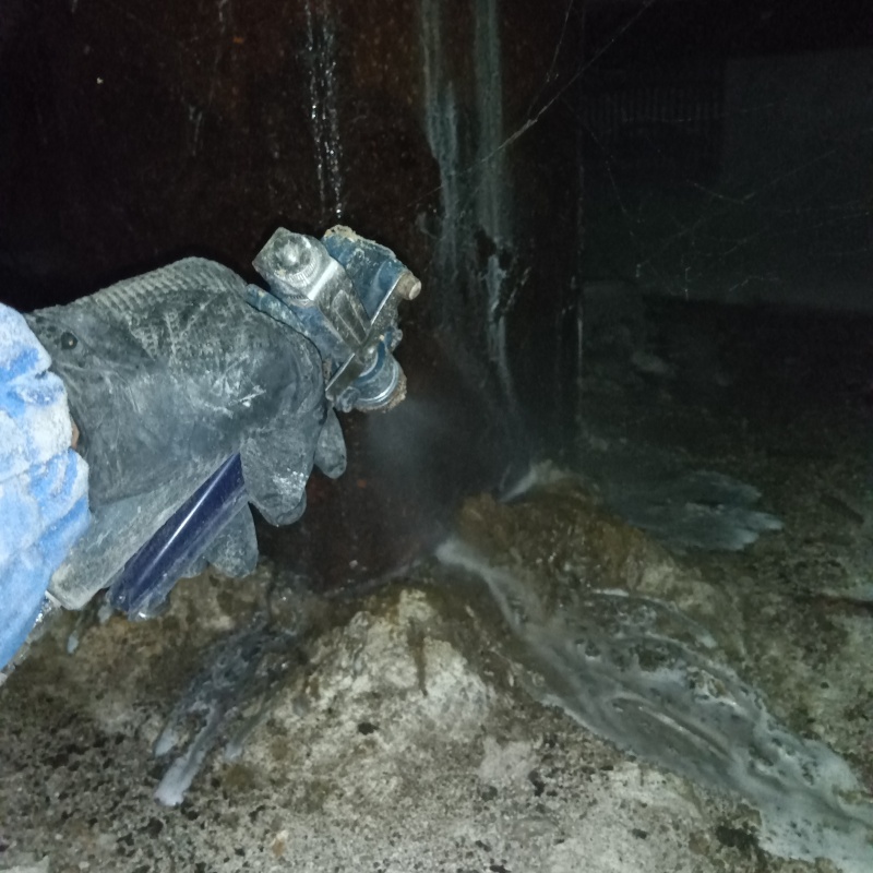 地面にシロアリ駆除剤を吹き付ける様子