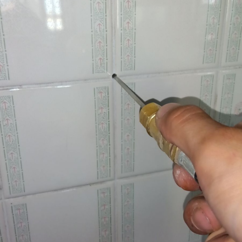 トイレの壁の目地からシロアリ駆除剤を注入