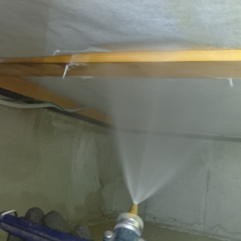 床下断熱材に防蟻剤を吹き付ける様子