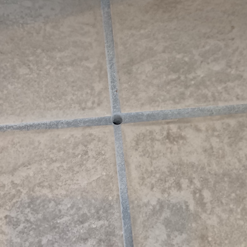 玄関床の目地に穴を開けて防蟻剤を注入