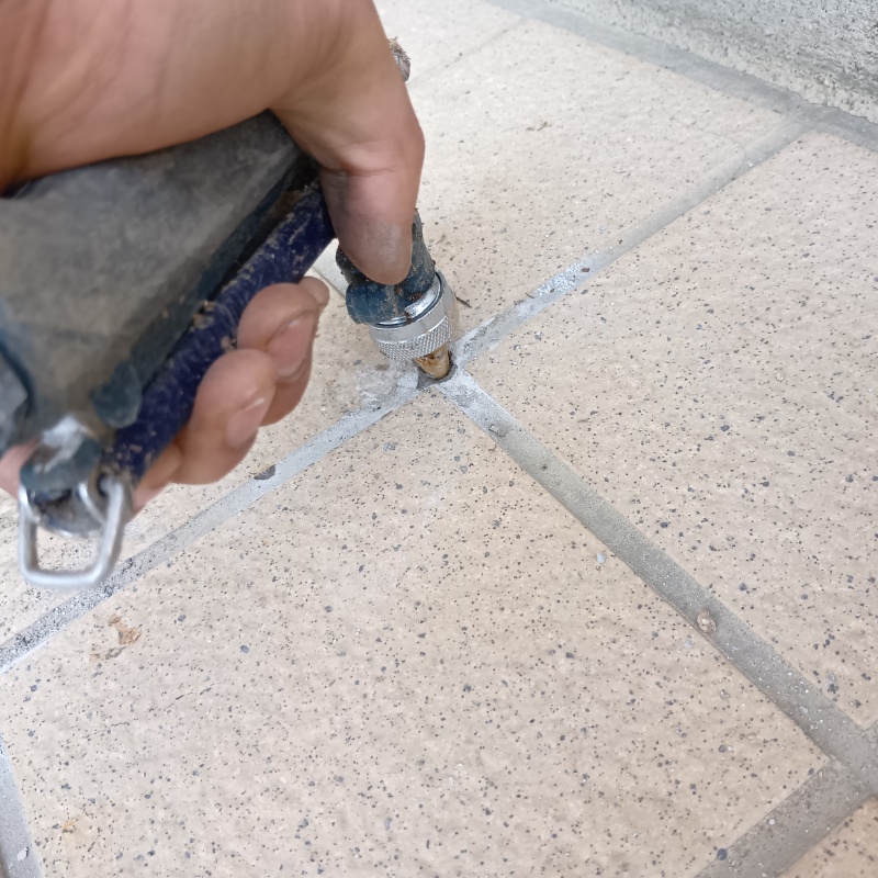 玄関床のタイルの目地からシロアリ駆除剤を注入