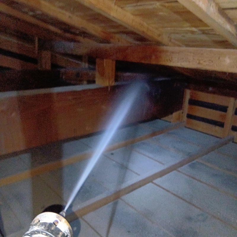 屋根裏の木材にシロアリ駆除剤を散布