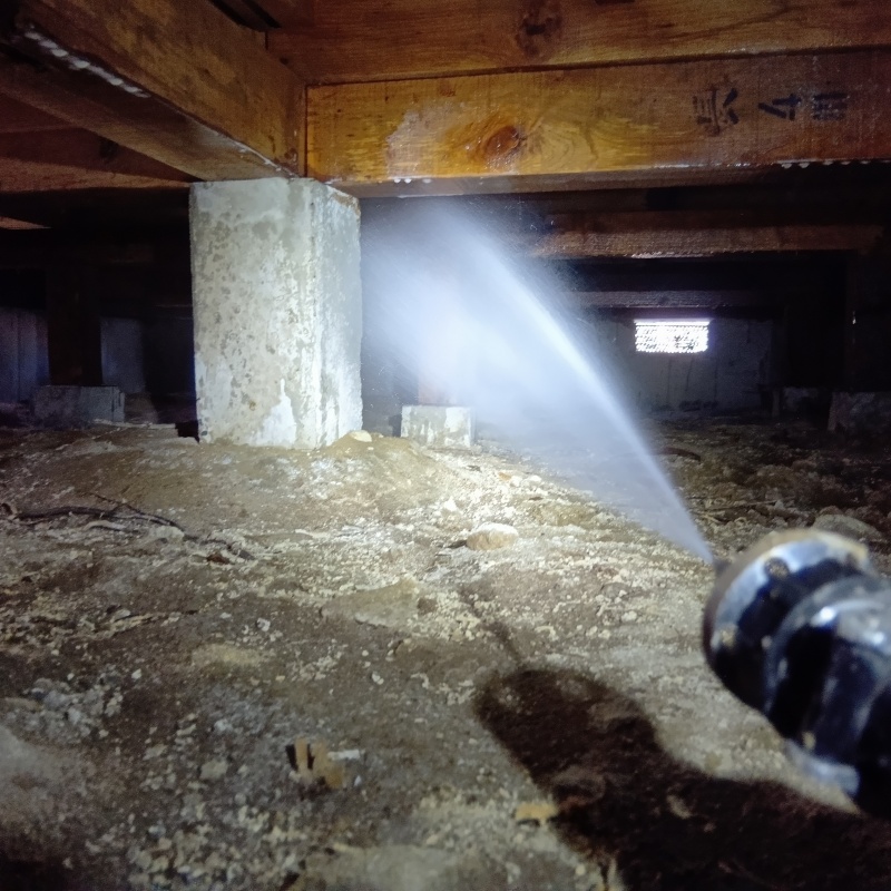 地面にシロアリ駆除剤を散布