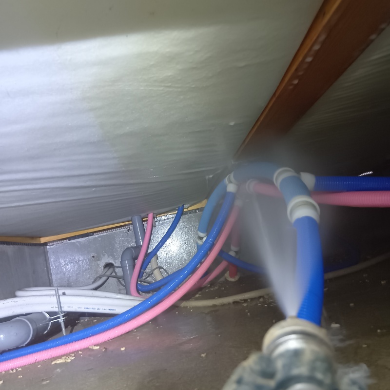 床下断熱材に防蟻剤を吹き付ける様子