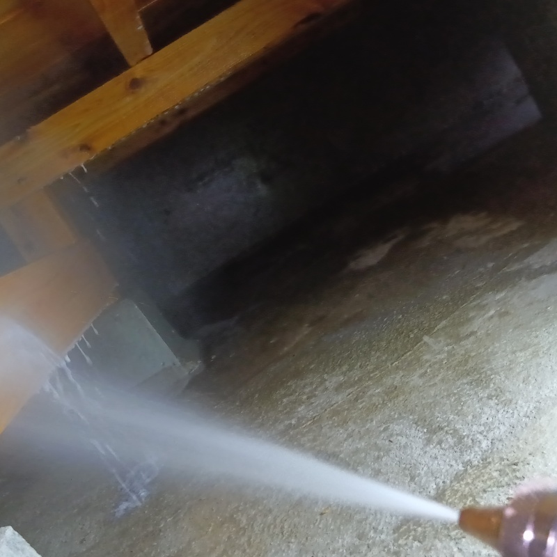 床下木材に防蟻剤を吹き付ける様子