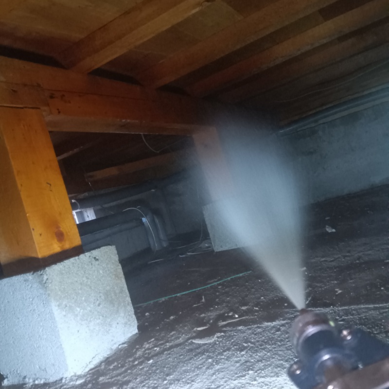 床下木材にシロアリ駆除剤を吹き付ける様子