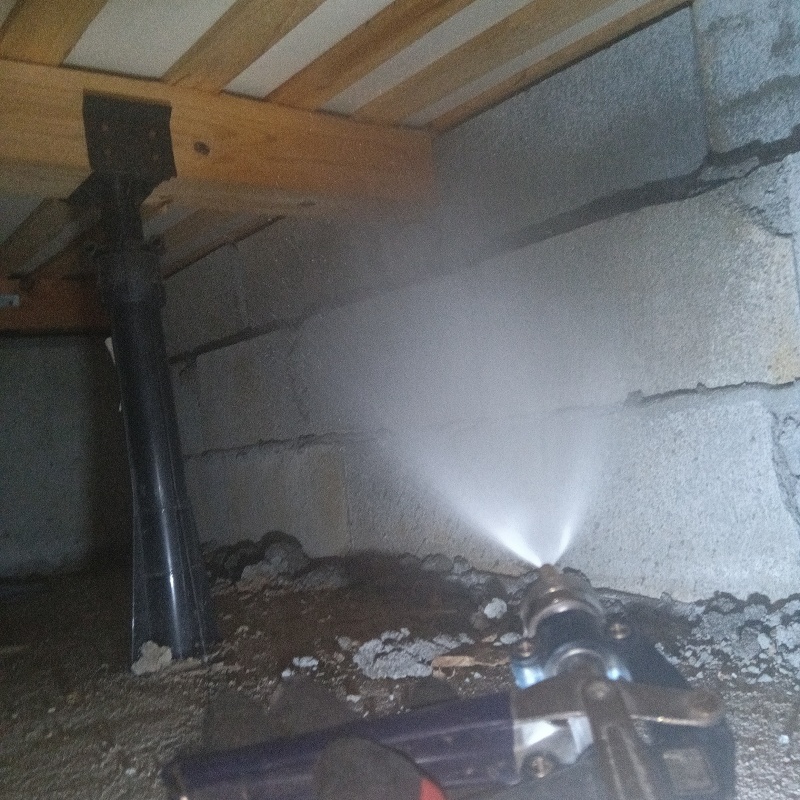 基礎にシロアリ駆除剤を吹き付けている様子