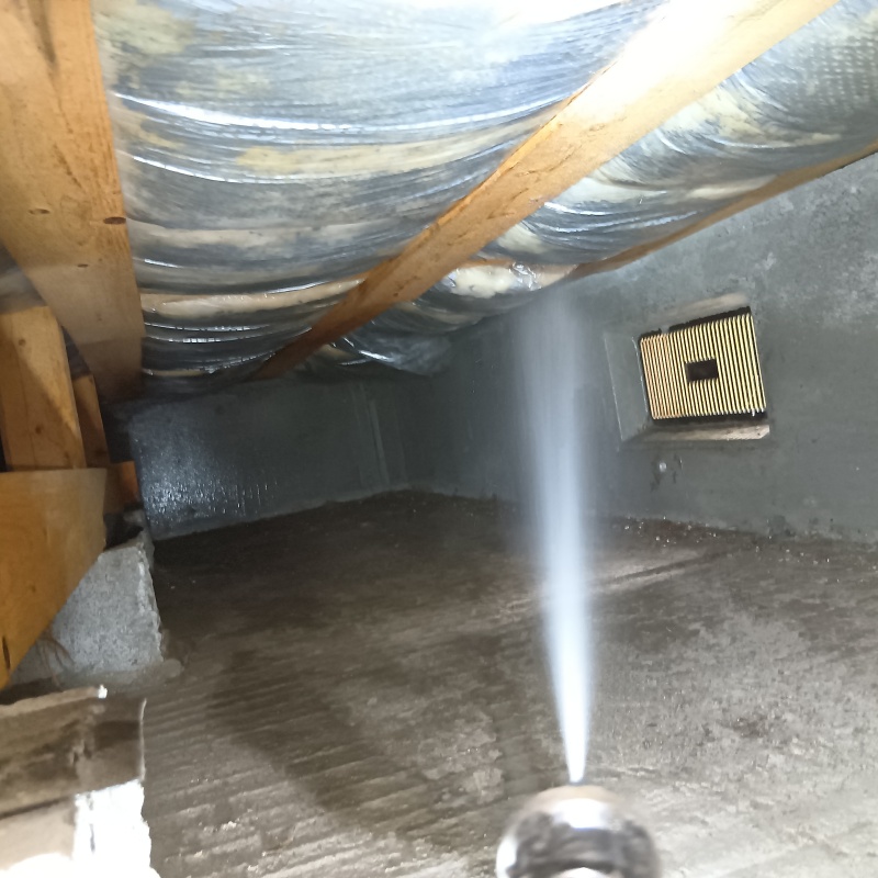 床下断熱材に防蟻剤を吹き付ける様子