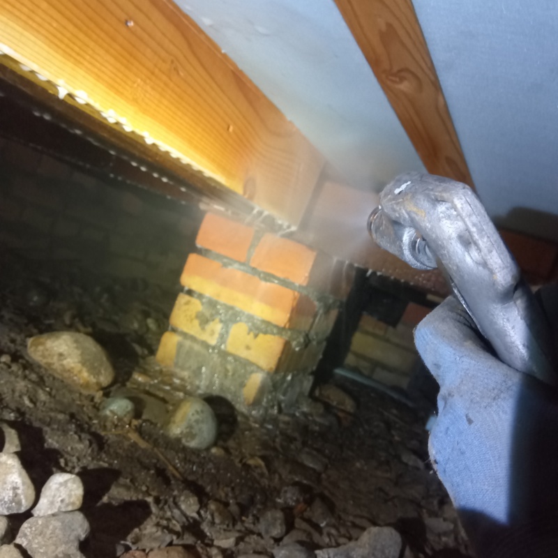 床下断熱材にシロアリ駆除剤を吹き付ける様子