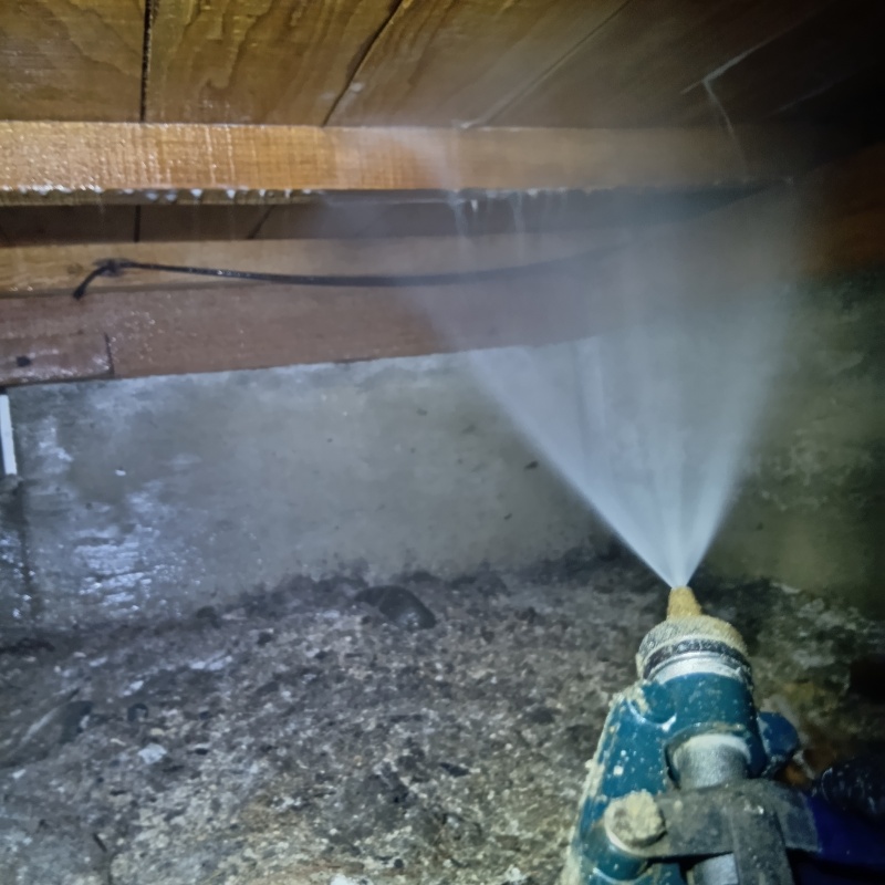 床下木材に防蟻剤を吹き付ける様子