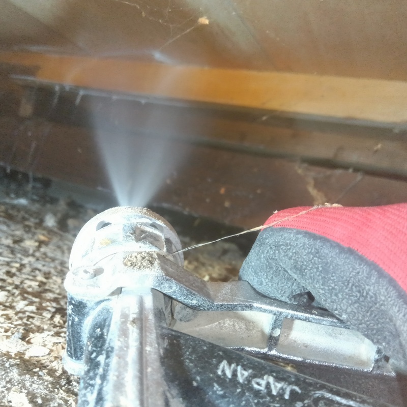 床下木材にシロアリ駆除剤を吹き付ける様子