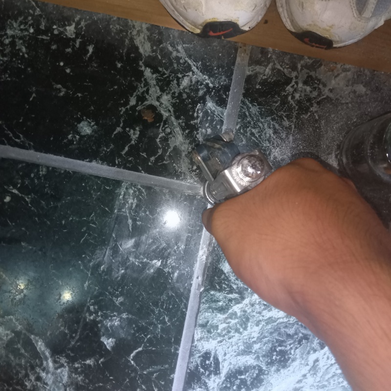 玄関床の目地に穴を開けてシロアリ駆除剤を注入